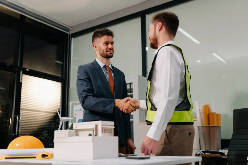 Handschlag zwischen Kunde und Bauingenieur im Büro